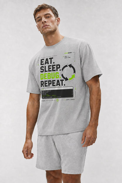 Head-safe close-up of a model wearing the Athletic Heather Eat. Sleep. Debug. Repeat. oversized boxy tee.