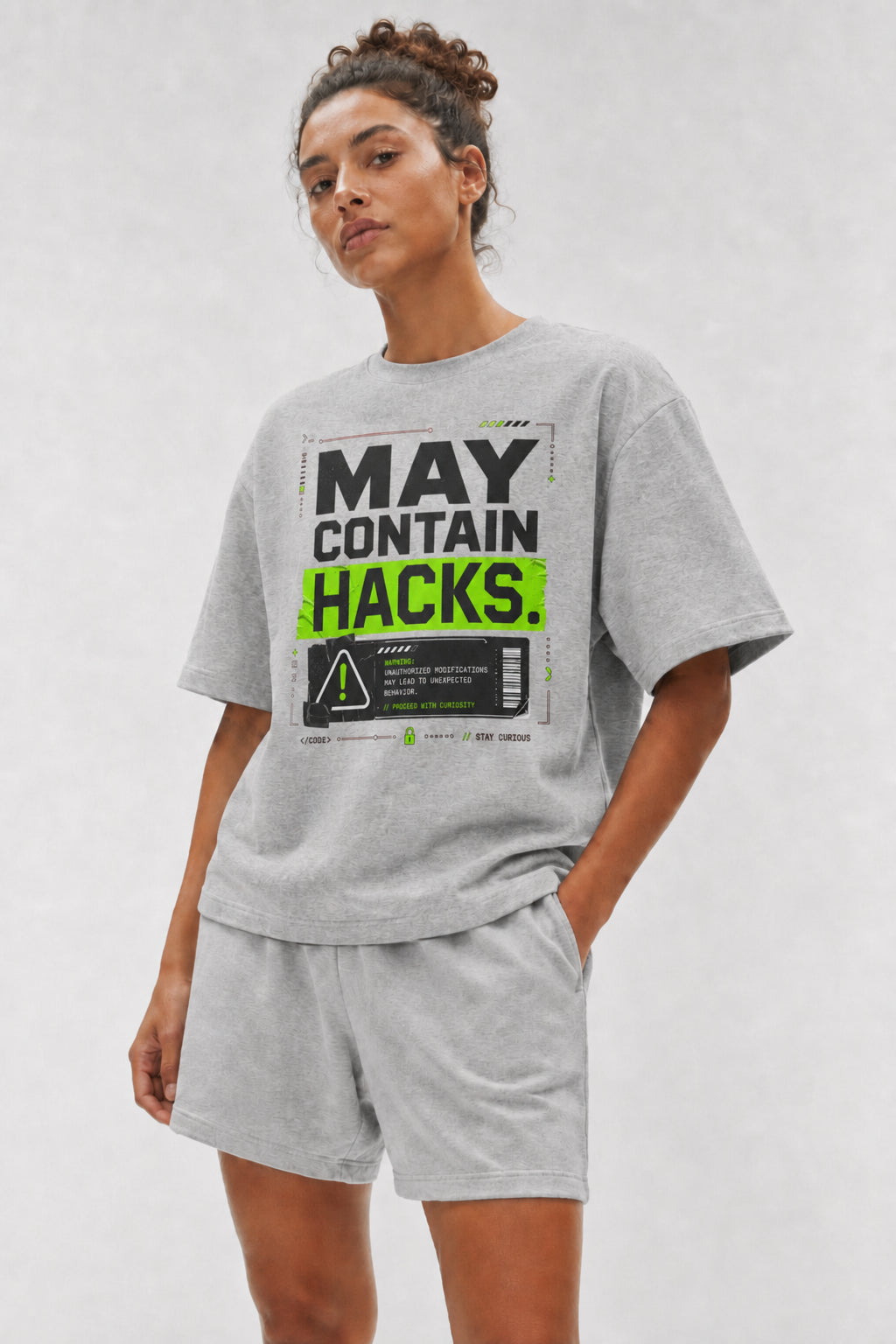 Head-safe close-up of a model wearing the Athletic Heather May Contain Hacks oversized boxy tee.
