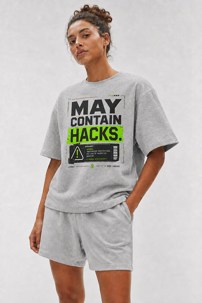 Head-safe close-up of a model wearing the Athletic Heather May Contain Hacks oversized boxy tee.